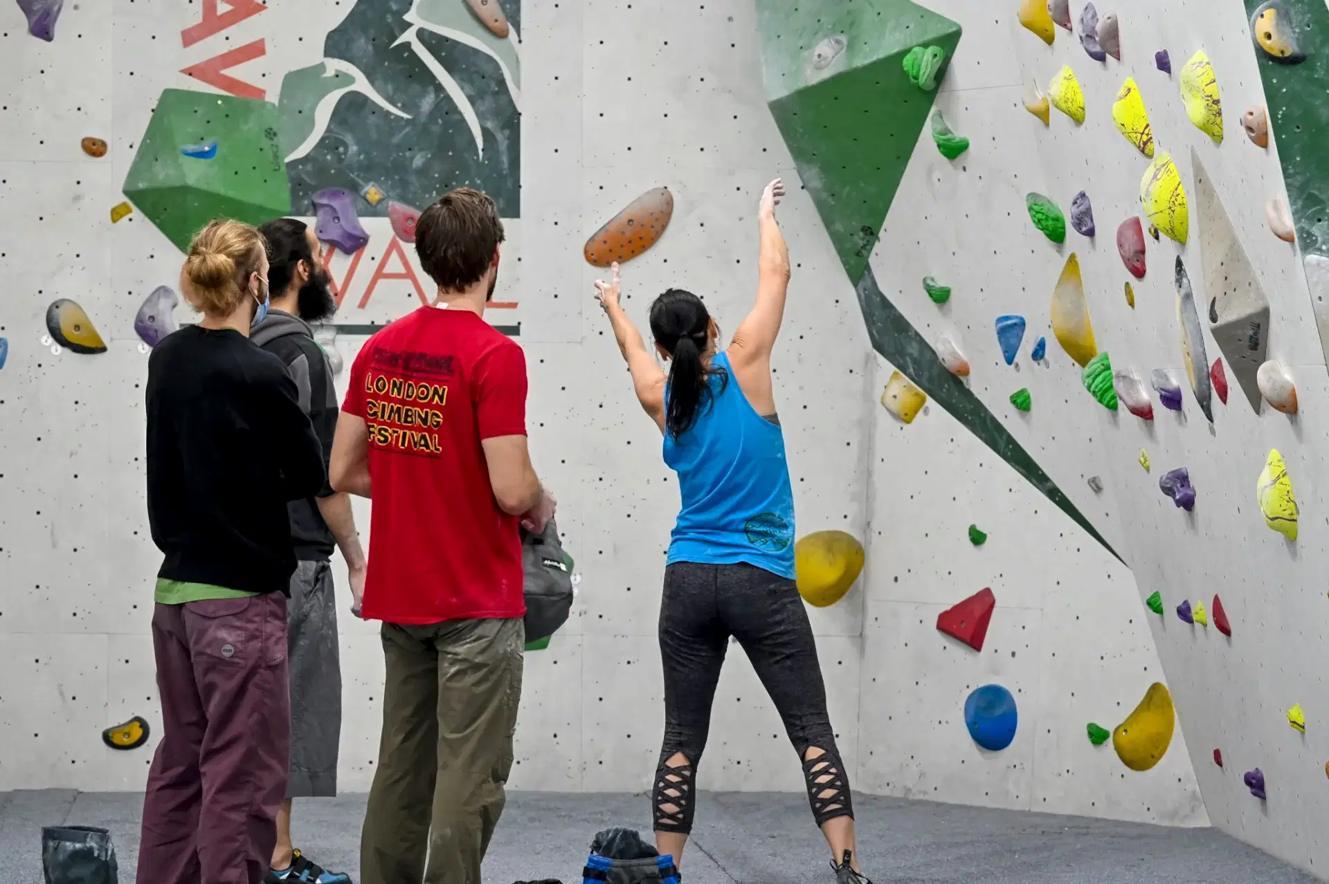 A group looking at a climibing wall on a boudlerama social  